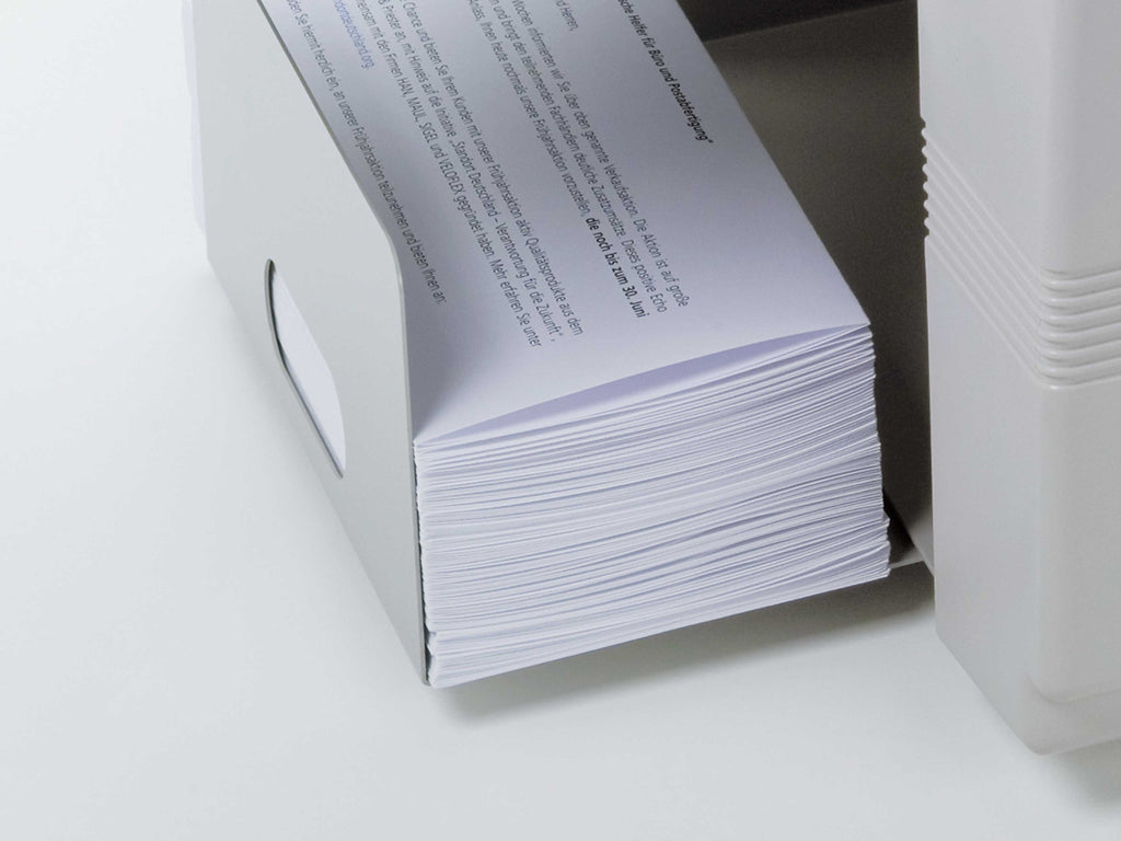 Nahaufnahme auf DIN lang gefalzter Briefe im Papierauswurf-Fach der Falzmaschine IDEAL 8324. Zu lesen ist ein Text aufDeutsch.