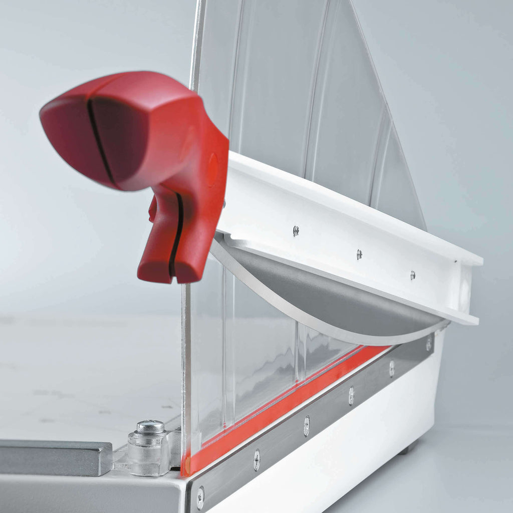 Detailansicht eines IDEAL 1046 Hebelschneiders, der Fokus liegt auf dem ergonomischen Griff des Messerhebels, des weiteren sieht man den Tisch in hochwertiger Ganzmetall-Konstruktion.