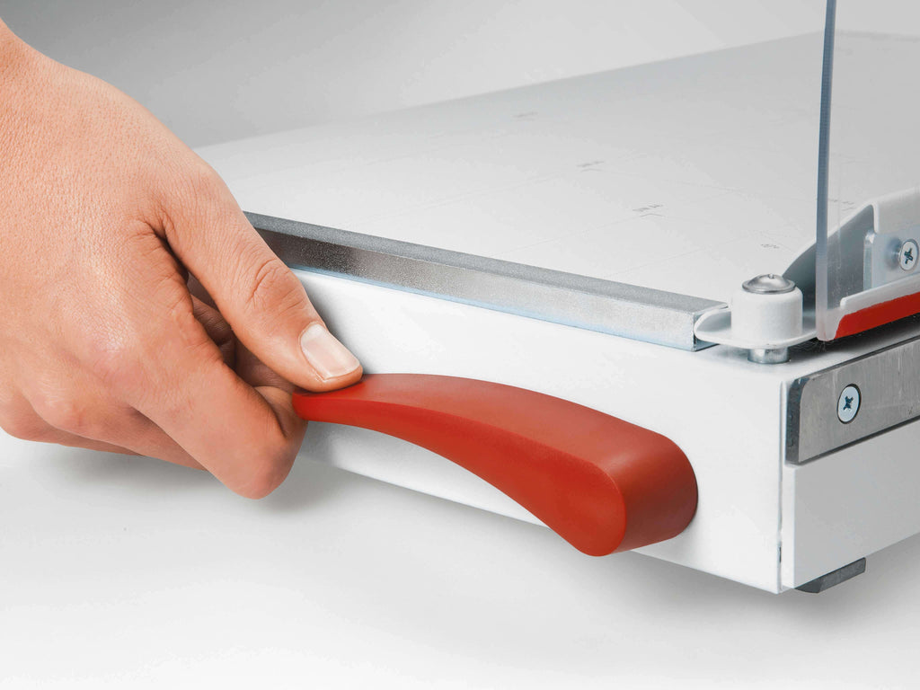 Seitenansicht des Hebelschneiders IDEAL 1135 – eine Hand betätigt den Hebel EASY-LIFT zum Lösen der automatischen Papierpressung - für eine bequeme Entnahme des Schnittgutes vom Schneidetisch.