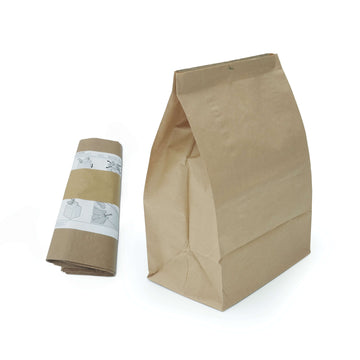 Vor weißem Hintergrund ist eine Verpackungseinheit mit fünf Papierfaltsäcken als Zubehör für IDEAL Aktenvernichter zu sehen. Abgebildet sind eine Rolle mit Säcken und ein aufgefalteter Sack.