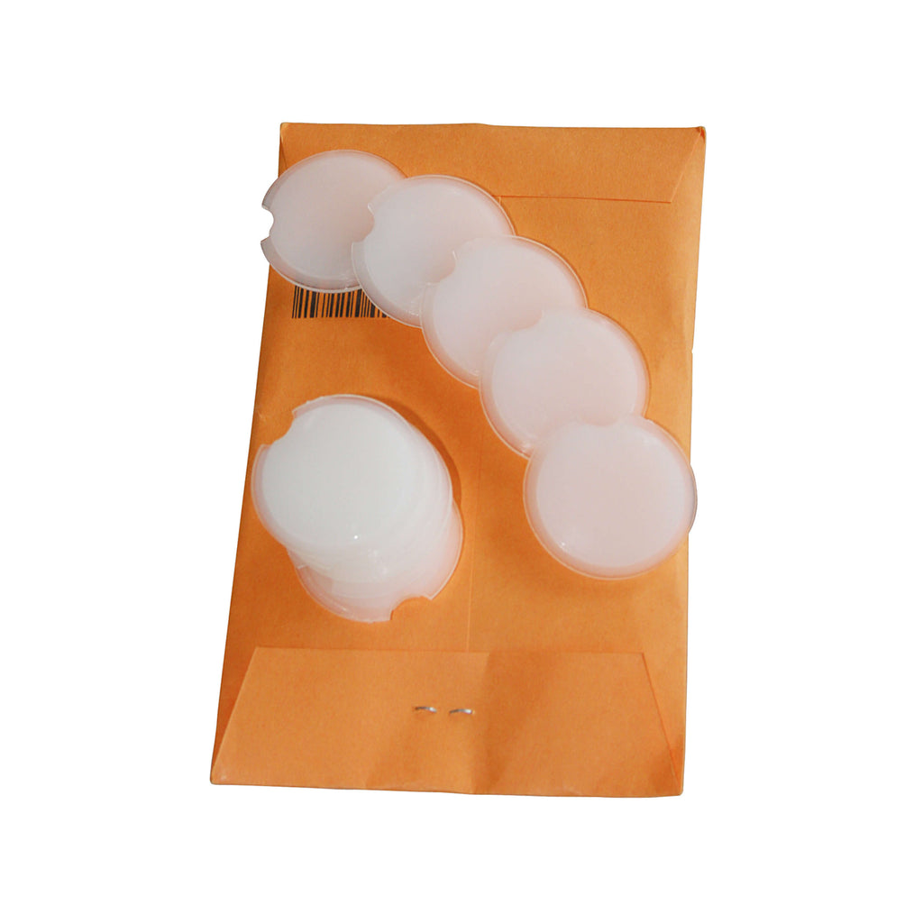 Ein Set mit 10 weißen Stanzpads als Zubehör für den Hochleistungslocher IDEAL 8570, auf einem Kuvert liegend.