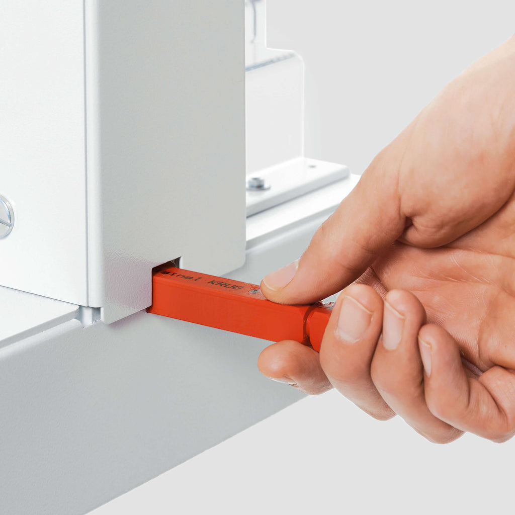 Das Bild zeigt in Nahaufnahme den Schnittleisten-Wechsel bei einem IDEAL-Stapelschneider. In der Szene hält eine Hand die rote Schnittleiste beim Austausch.