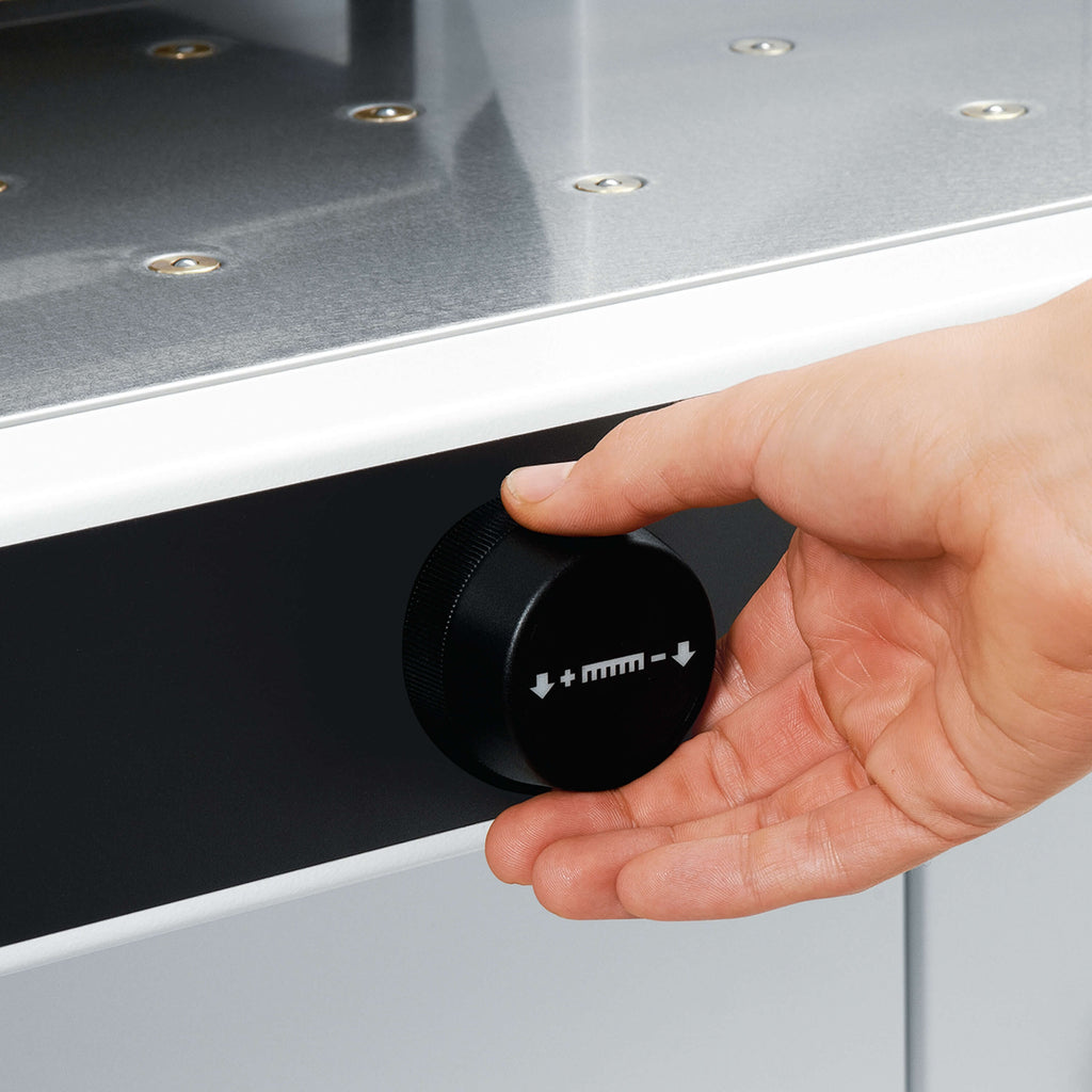 Nahaufnahme auf die Frontseite des elektrischen Stapelschneiders IDEAL 5560 LT. Zoom auf eine Hand, die im Begriff ist, am elektronischen Handrad zu drehen.