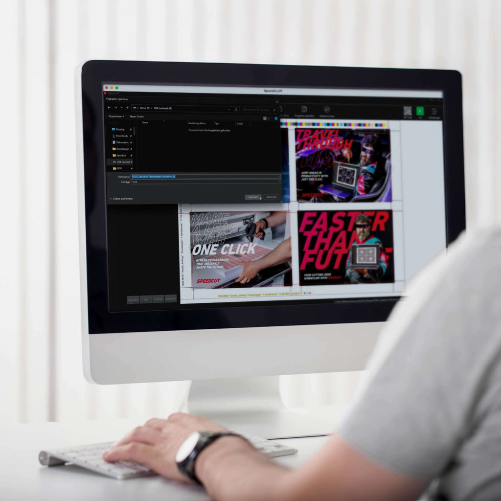 Von hinten fotografierter Bediener des programmierbaren Stapelschneiders IDEAL THE56 oder IDEAL THE68, der auf den Monitor eines iMACs blickt. Auf dem Bildschirm ist ein Schnittbogen mit futuristischem Motiv in 4 Nutzen zu sehen. Die Software Speedcut erstellt automatisch ein fertiges Schnittprogramm aus diesem Druckbogen, ohne Programmieraufwand oder Vorwissen. Das PDF mit Schnittmarken ist geladen, der Rest wird von der Software übernommen.