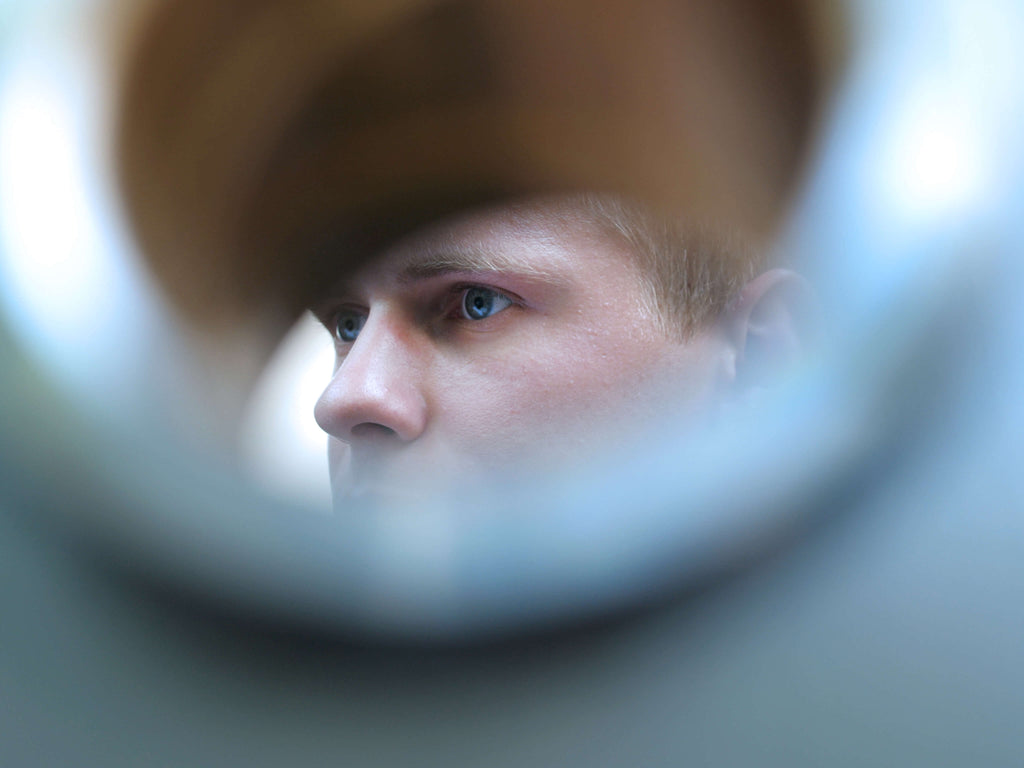 Eine Nahaufnahme des Gesichts einer Person, umgeben von einem unscharfen, runden und hellen Rahmen.