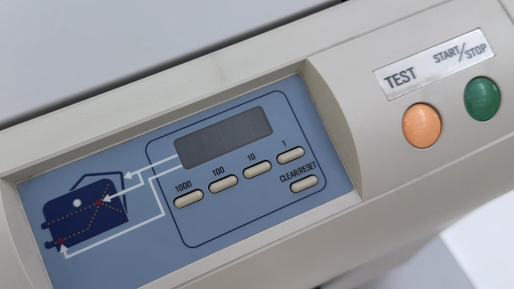 Das Bild zeigt das Bedienpanel der Falzmaschine IDEAL 8324 - rechts zwei Buttons für TEST und START/STOP. Links ein Zahlendisplay und Tasten für die Zähler 1000, 100, 10, 1 und eine weitere Taste mit CLEAR/RESET.