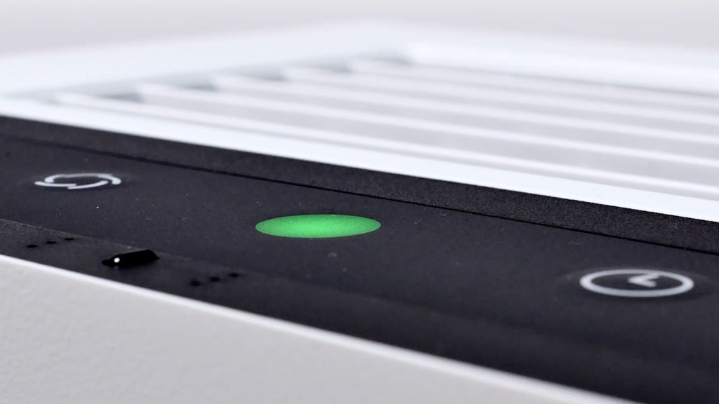 Oberflächen-Bild mit Detailansicht des Bedienpanels eines Luftreinigers IDEAL AP60 PRO oder AP80 Pro. In der Mitte leuchtet eine grüne Anzeige, links und rechts davon sind Touch-Bedien-Buttons.