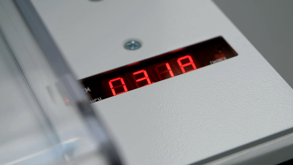 Vorschaubild zum Video mit Zoom auf den Schneidetisch des Stapelschneiders IDEAL 4315: Der Fokus liegt auf der digitalen Maßanzeige mit leuchtend roten Zahlen. 